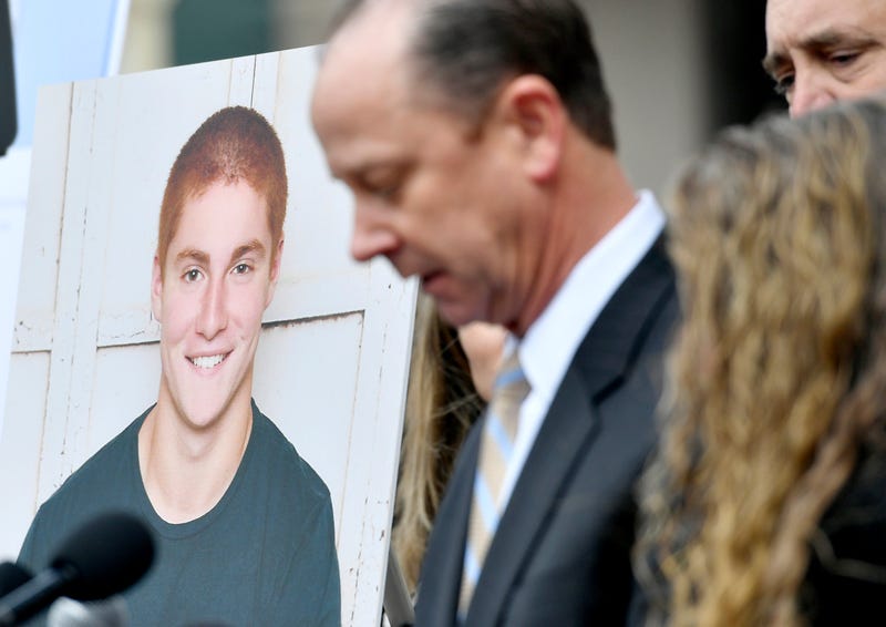 A large photo of Timothy Piazza next to his father Jim Piazza as he speaks about the importance of passing the anti-hazing legislation named after his son outside of the Centre County Courthouse on March 23, 2018, in Bellefonte, Pennsylvania.