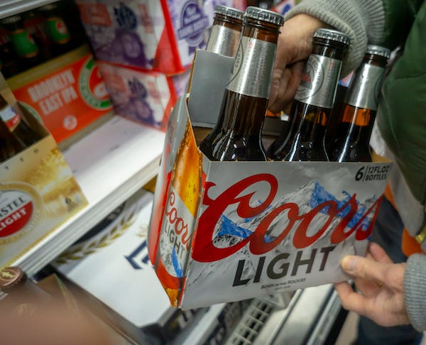 Customer holding a six-pack of Coors Light