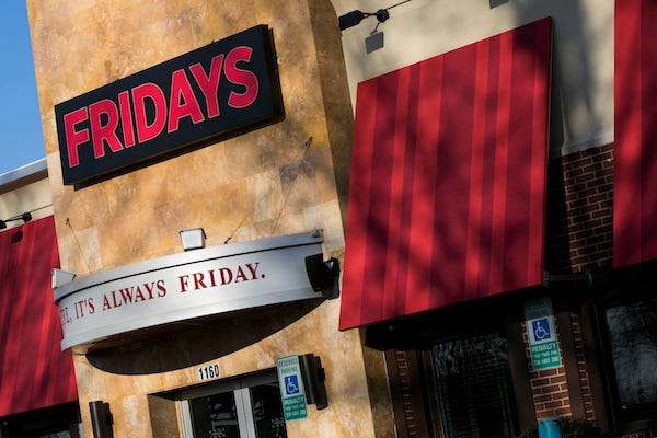 A logo sign outside of a TGI Fridays restaurant location in Fredericksburg, Virginia on February 19, 2019