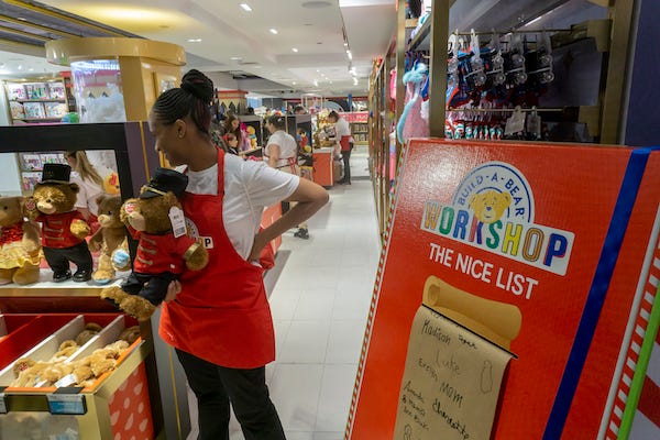 A worker in the Build-a-Bear workshop section greets customers