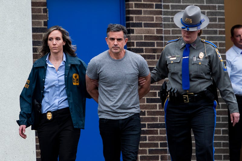 Fotis Dulos is escorted out of the Troop G State Police station before being placed in a cruiser Tuesday afternoon, Jan. 7, 2020