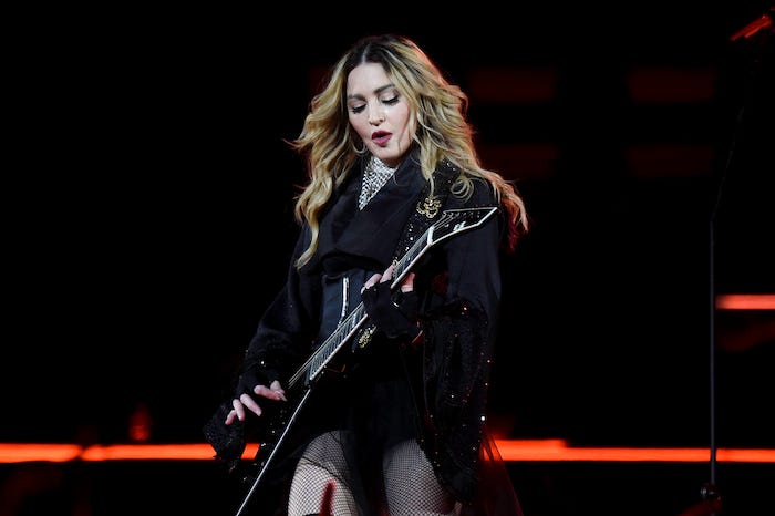 Madonna playing guitar during concert