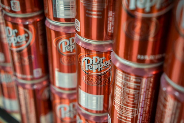 Cans of Dr Pepper soda on a supermarket shelf