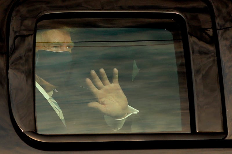 U.S. President Donald Trump waves to his supports from a motorcade outside Walter Reed Medical Center during his treatment of COVID-19 in Bethesda, Maryland on October 4, 2020