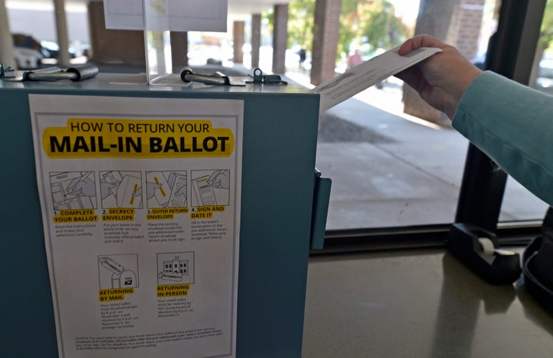 A woman drops her mail-in ballot into the drop box at the Luzerne County Board of Elections on Oct. 22, 2020.