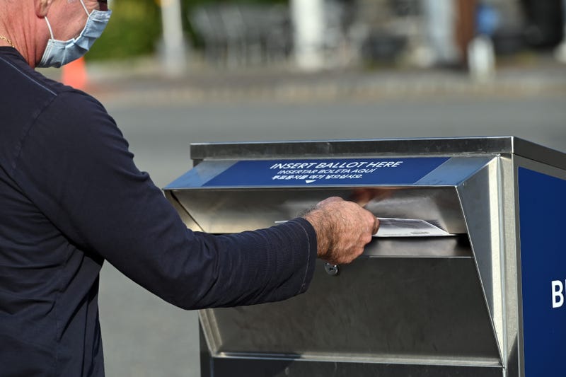 A man deposits his ballot in an election ballot drop box