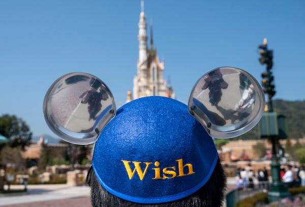 An employee wears a Micky Mouse theme hat at the entrance of the Hong Kong Disneyland Resort 
