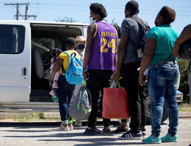 Haitian migrants who are seeking asylum wait to get into a van to be transported from Del Rio, Texas