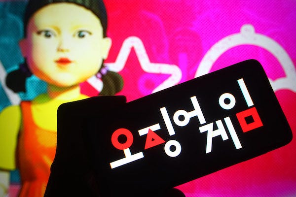 Squid Game logo on smartphone and Red Light, Green Light girl