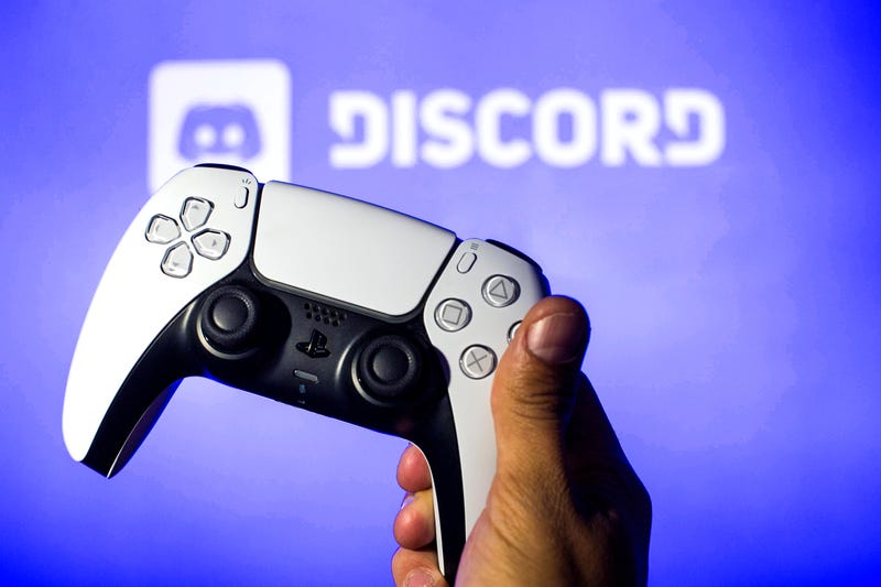 In this photo illustration, a PlayStation 5 controller seen with a Discord logo in the background.