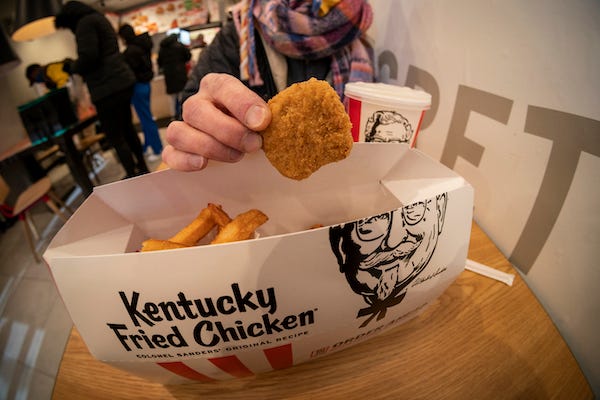 A woman enjoys a combo order of Beyond Fried Chicken at a KFC in Midtown Manhattan