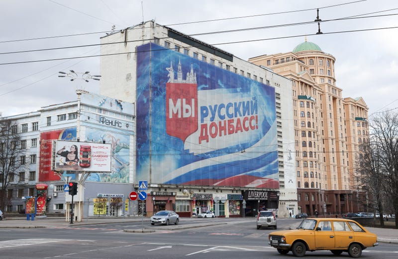 A poster reading "We are Russian Donbas" and bearing a Russian flag is pictured at a building in Donetsk, Ukraine. Denis Pushilin, head of the Donetsk People's Republic, had asked Russian President Vladimir Putin to recognize the region's independence