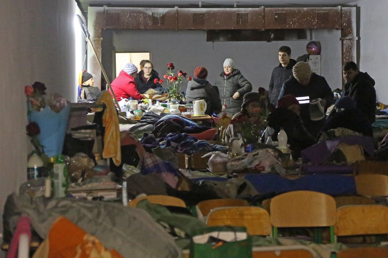 People are pictured in a bomb shelter in the village of Sartana, east of Mariupol.