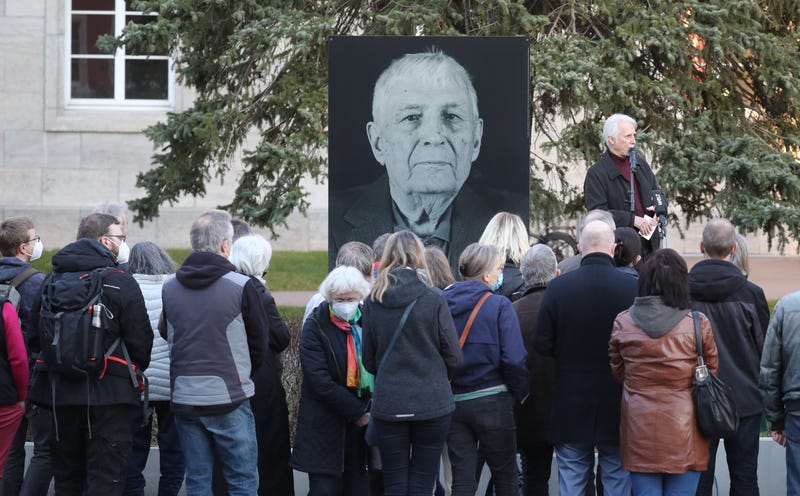 Participants of a memorial service for Buchenwald survivor Boris Romantschenko stand in front of his photo. 96-year-old Boris Romanchenko was killed in a bombing raid in Kharkiv. 