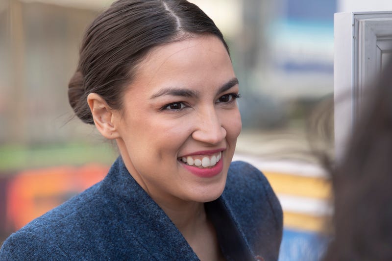 United States Congresswoman Alexandria Ocasio-Cortez talks with a local activist outside the Queensboro restaurant in Jackson Heights in New York City.