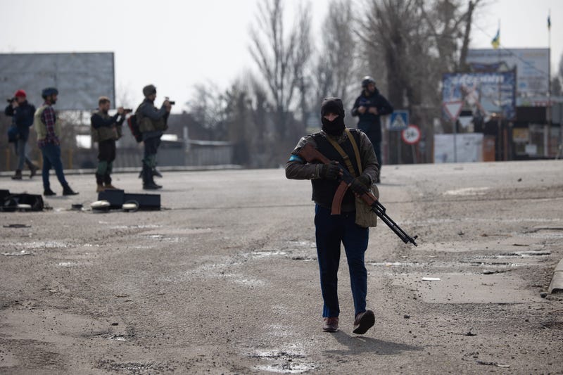 Ukrainian soldiers from the Civil Defense stand next to damage gas station and buildings after Russian Shelling in Stoyanka, near Kiev, on March 31, 2022