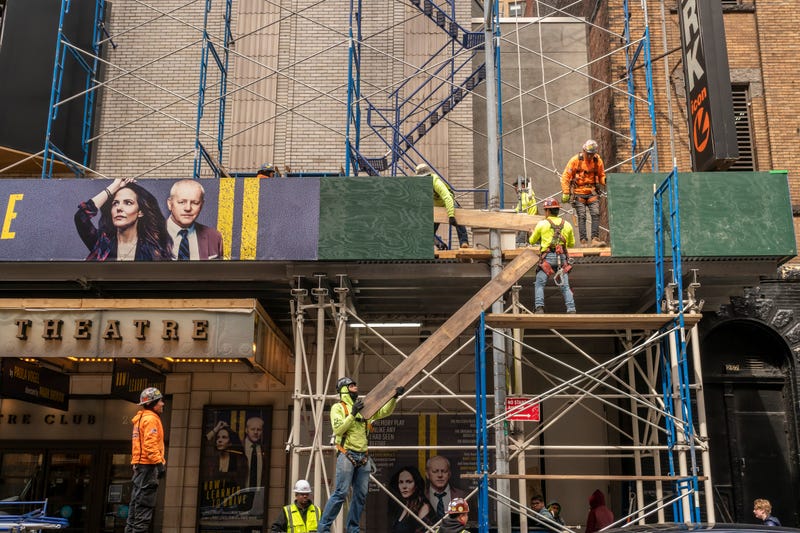 Construction crews work on a sidewalk shed on W. 47th Street near Times Square