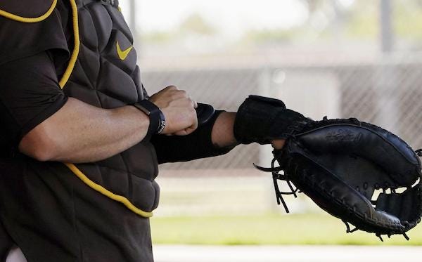 San Diego Padres catcher Victor Caratini tests a device used to call pitches, Pitchcom