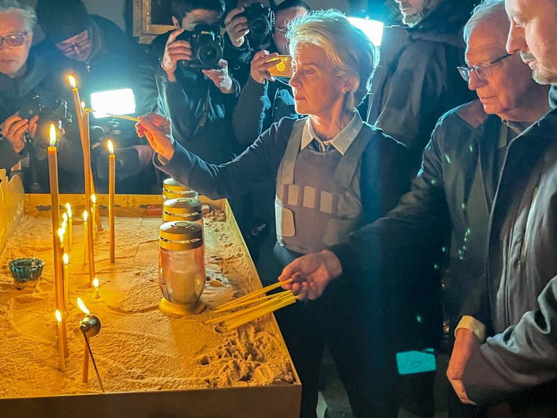 08 April 2022, Ukraine, Butscha: EU Commission President Ursula von der Leyen and EU High Representative for Foreign Affairs Josep Borrell (2nd from right) light candles for the victims of the massacre in a church next to a mass grave.