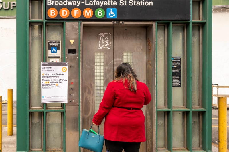A woman waits for an elevator to take her into the subway at the Broadway–Lafayette Street/Bleecker Street station in SoHo