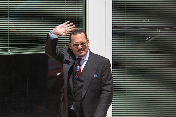 Johnny Depp waves to fans outside of the Fairfax County Courthouse during the defamation case brought by Depp against his ex-wife Amber Heard