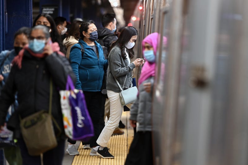 Commuters wear masks as they get on and off a subway train in Queens on May 3, 2022
