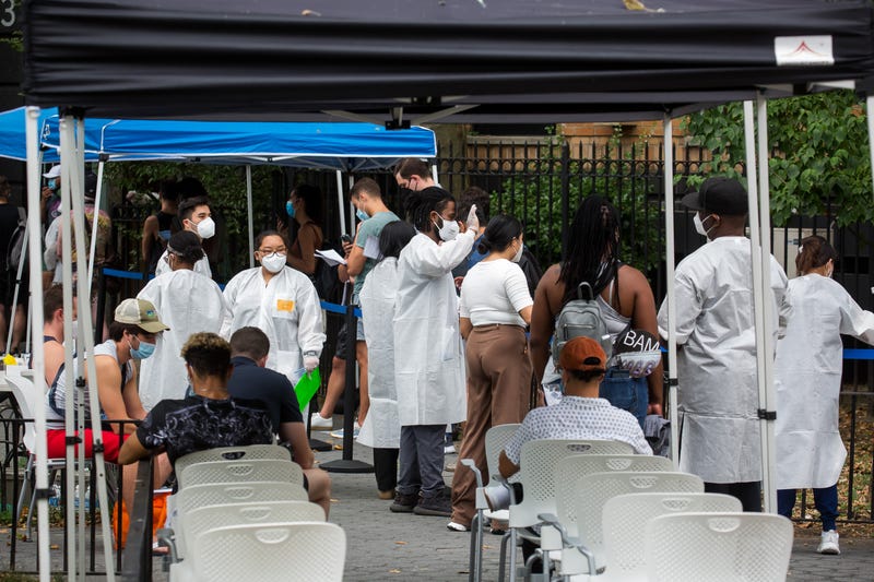 Health care workers assist people waiting to be vaccinated at a monkeypox vaccination site in New York City on July 14, 2022