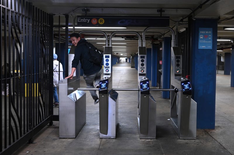 A man is seen hopping over a subway turnstile in Queens on Oct. 17, 2022