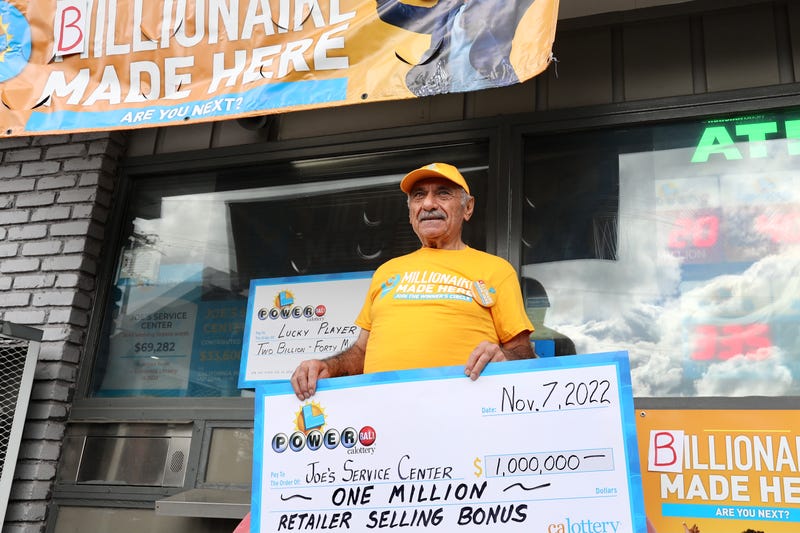 Business owner Joe Chahayed holds a Powerball bonus check outside Joe's Service Center that sold the winning Powerball ticket of $2.04 billion in Altadena, California on Nov. 8, 2022.