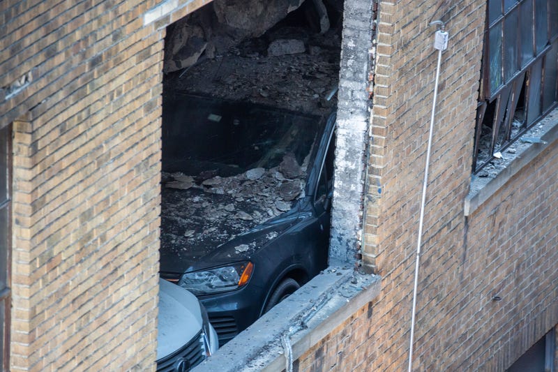 A car is seen covered in rubble at the parking garage on Wednesday morning