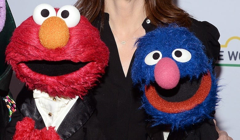 Elmo and Grover posing on the red carpet at the Sesame Workshop's 2023 Benefit Gala