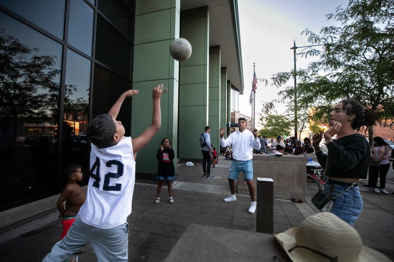 Migrants play volleyball outside the 9th District Police Station in Chicago on Aug. 17, 2023.