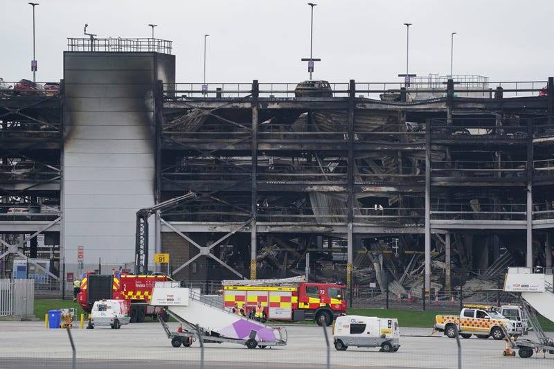 The burnt out shells of cars, buried amongst debris of a multi-story parking garage at Luton Airport in London. 