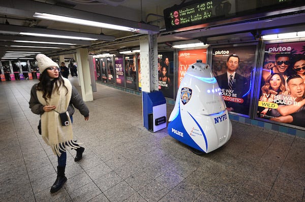 A woman walks past the NYPD’s Knightscope K5 Autonomous Security Robot at the Times Square subway station, New York, NY, November 22, 2023