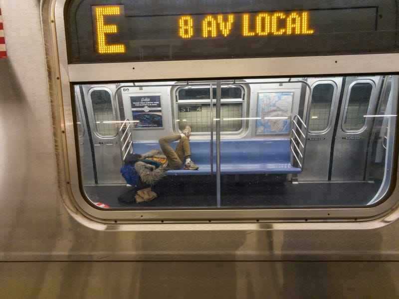 A homeless man sleeps on an E train on March 2, 2024