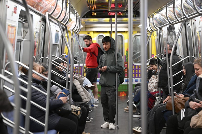 Commuters are seen on a Queens-bound R train on March 19, 2025