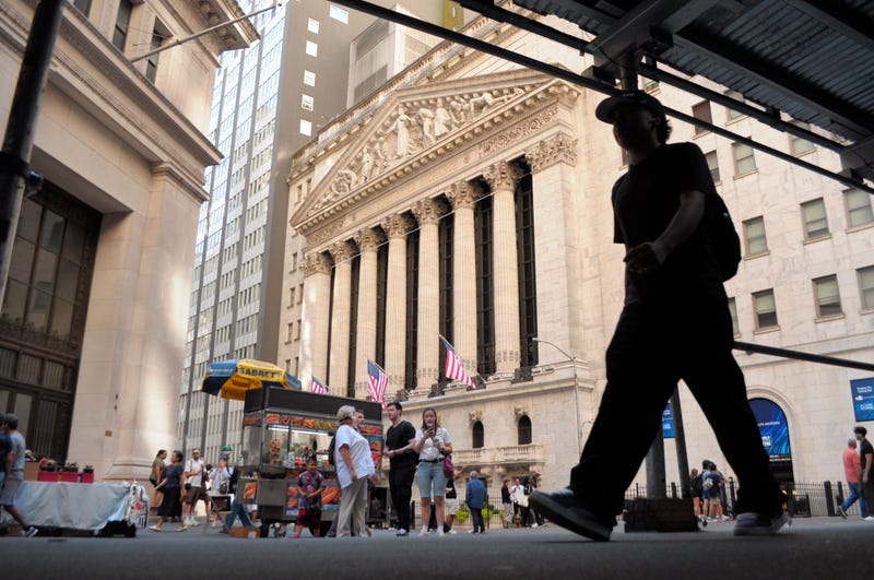 A person walks past the New York Stock Exchange in the Financial District in Manhattan in August