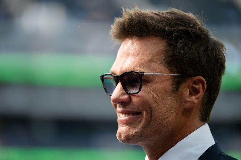 Tom Brady talks to fans before a game