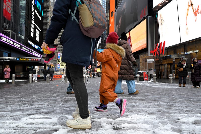 Pedestrians walk along wet and slushy streets in Manhattan. 