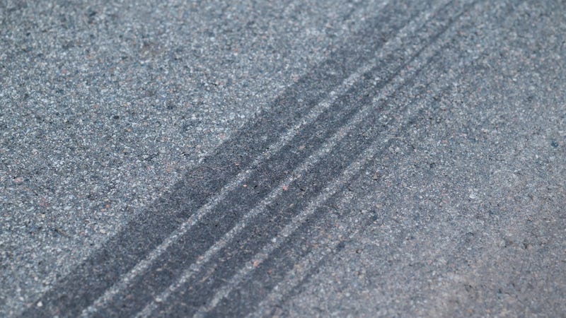 Skid marks left by tires on asphalt road - stock photo