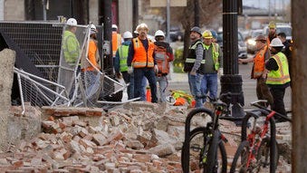 Construction workers looks at the rubble from a building after an earthquake Wednesday, March 18, 2020, in Salt Lake City. A 5.7-magnitude earthquake has shaken the city and many of its suburbs. (AP Photo/Rick Bowmer)