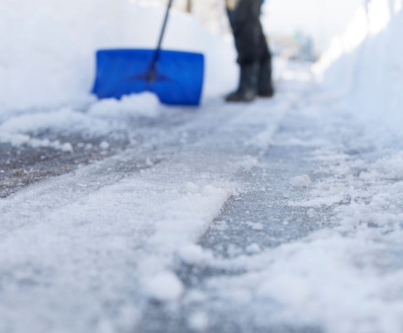 snow on sidewalk being shoveled