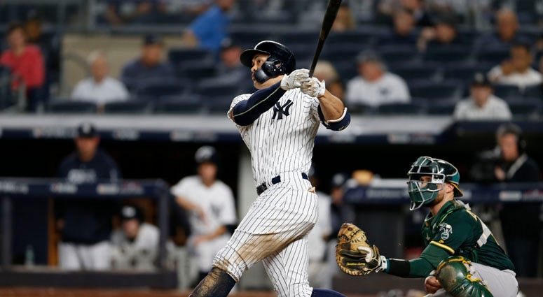 Yankees left fielder Giancarlo Stanton hits a solo home run during the eighth inning against the Oakland Athletics on Oct. 3, 2018, in a wild-card playoff game at Yankee Stadium.