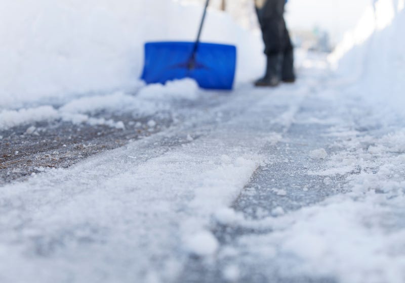 snow being shoveled along sidewalk