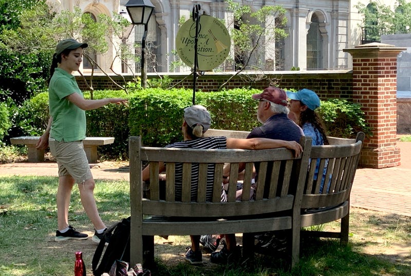 Storyteller Lucy Fletcher (left) regales guests at a Once Upon a Nation storytelling bench with a historic tale.