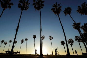 FILE - In this April 15, 2020, file photo, people keep their distance as they exercise outside of a closed La Jolla beach in San Diego. (AP Photo/Gregory Bull, File)