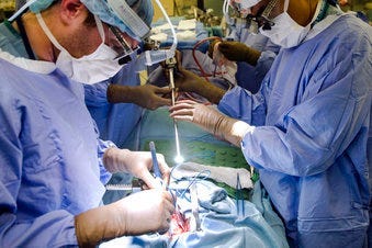 FILE - In this Tuesday, Jan. 23, 2018 file photo, a surgeon directs a special camera to be able to view his patient's cancer tumor on monitors while performing surgery at a hospital in Philadelphia. (AP Photo/Matt Rourke)