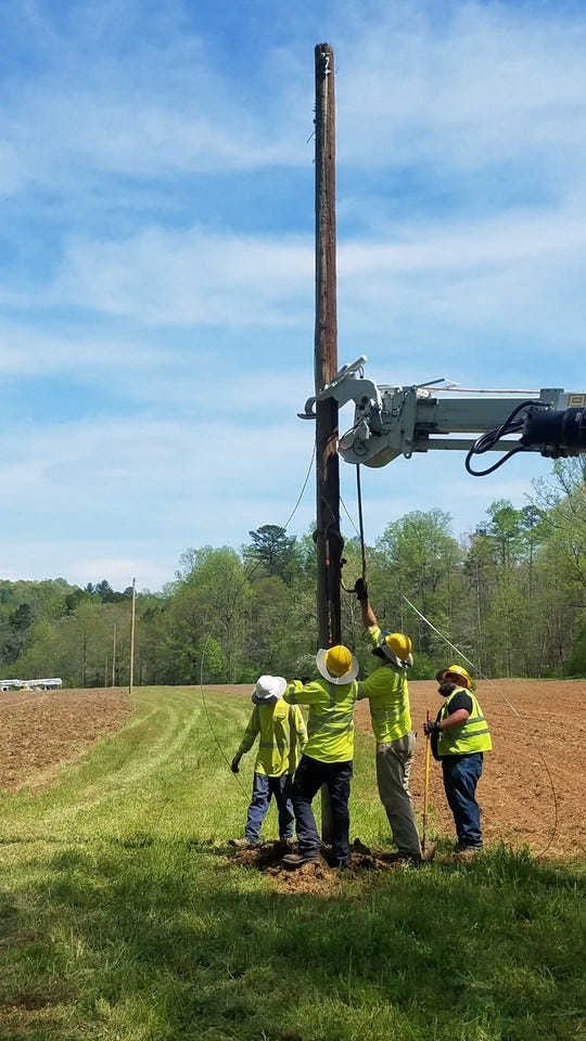 Blue Ridge Electric Cooperative crews erect anon-active power line across a dove field