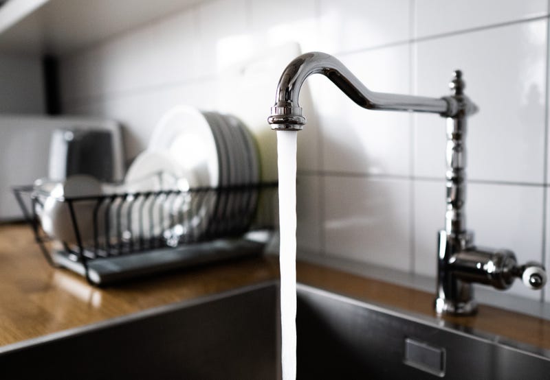 Water flowing out of a kitchen stainless steel tap into the sink
