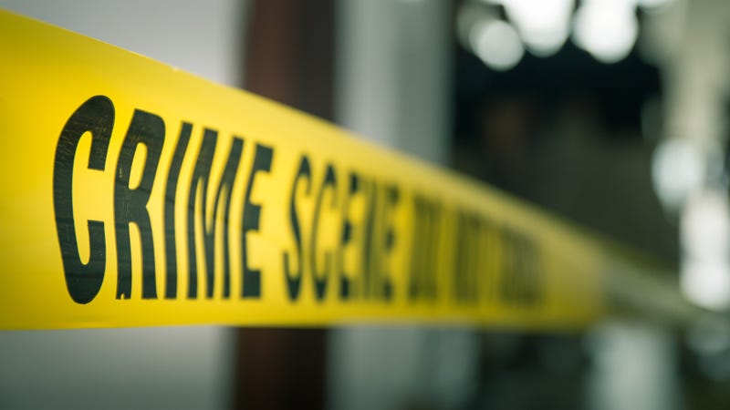 crime concept by police line tape with blurred forensic law enforcement background